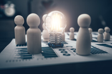 light bulb represents good idea center of The wooden doll represents the employee of the company on financial, budget or asset document in workplace. Security, save,  Corporation, Enterprise concept.