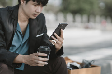 Employees fired or resigned from the company are using their mobile phones to search for jobs..Unemployed, hiring job, quitting job concept.