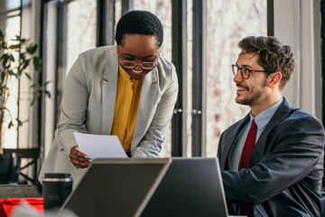 Two young business people having a successful meeting in modern office.