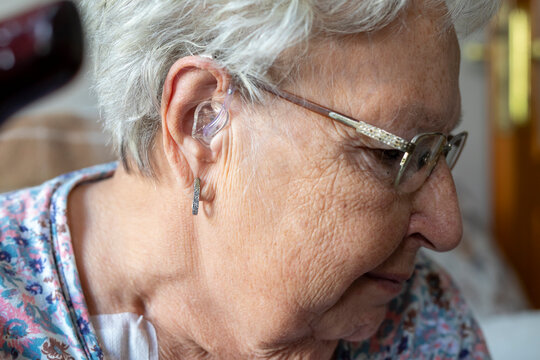 woman wearing digital hearing aid - Powered by Adobe
