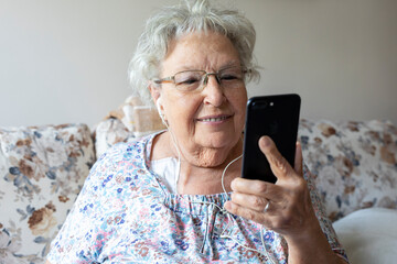 Elderly woman talks on a mobile phone home