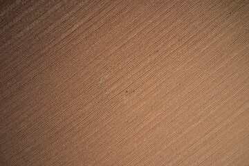 Plowed field top view. Large plowed field aerial view. Brown earth top view.