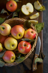 Ripe apples in a basket, with leaves around it