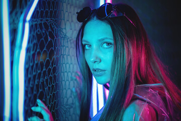 Beautiful cyberpunk girl in the transparent jacket in the neon lights concept.