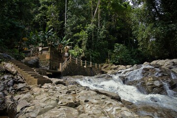 Idyllic shot of the smaller of the two Tibumana waterfalls in Ubud on Bali flowing down rocks...