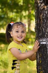 A little girl in the forest. A child walks in nature on a sunny day.