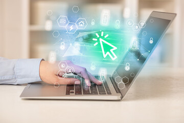 Hands working on laptop with digital icons