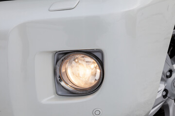 Front bumper fog lamp view of silver car after cleaning before sale in a workshop for repair and...