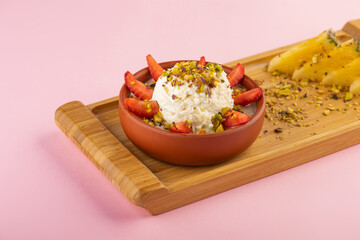 Mohalabiya with banana, strawberry, nut, raisin, and honey closeup shot 