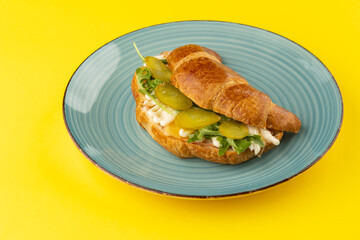 Breakfast of Fresh croissant with Turkey, mayo and pickles   