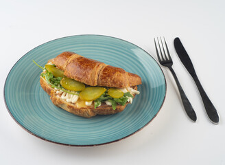 Breakfast of Fresh croissant with Turkey, mayo and pickles   