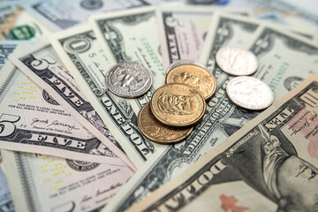different United States dollar bills with coins for background