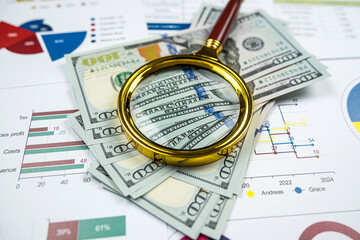 Business graph graphs paper with us dollar bills and magnifying glass