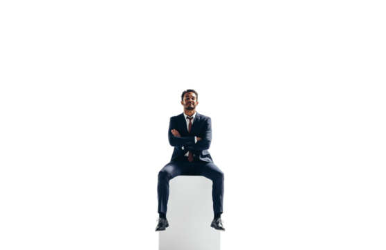 Confident young businessman sitting on top of a block on a transparent background - Powered by Adobe