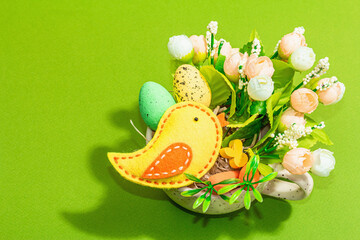 Easter bouquet in a cup. Traditional flowers, decorative quail eggs. Trendy green background