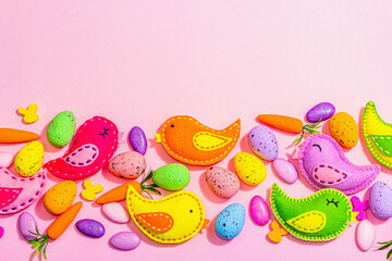 Handmade Easter background with colorful felt birds. Decorative eggs and sweet candies, cute rabbit