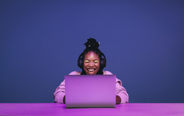 Cheerful female gamer winning an online game on a laptop - obrazy, fototapety, plakaty