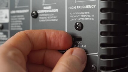 Man adjusting the audio settings of a studio monitor. Close up