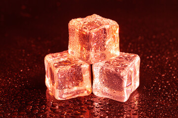 Red ice cubes on black background.