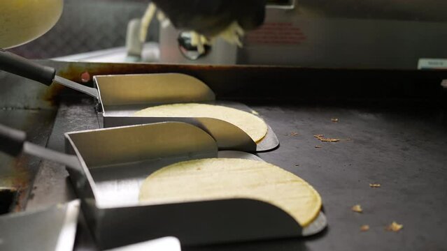 Warming corn tortilla shells to melt cheese for a mulita - food truck series