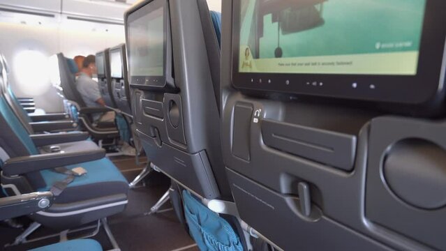 Economy Class Cabin Of A Passenger Airplane With Comfortable Seats And Touch-screen Monitors For Entertainment. closeup