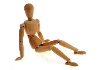 Mannequin articulé en bois assis en gros plan sur fond blanc