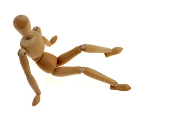 Mannequin articulé en bois assis vu de dessus en gros plan sur fond blanc