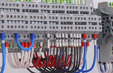 Electrical screw terminals with connected insulated copper wires with metal tips. The wires are marked with thermal printing.