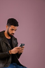 Fototapeta premium Portrait of young multiracial man with smartphone in studio.