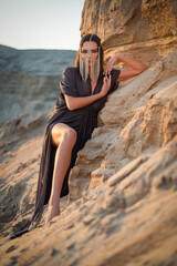 A young beautiful girl in the dress in the sand desert concept.