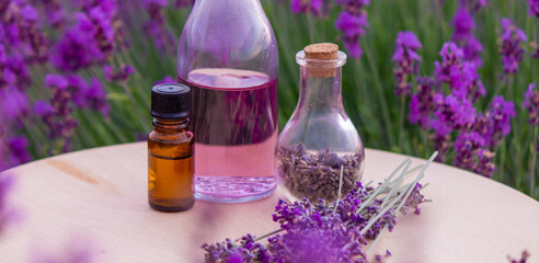 Obraz na płótnie Canvas jars with lavender oil, lavender flowers, on the background of a lavender field.