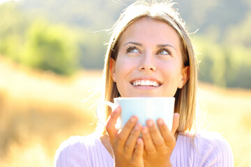 Happy teen laughing drinking coffee in nature