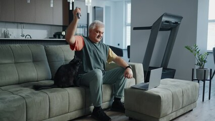 Home Fitness In Old Age, Senior Man Watching Online Workout And Doing Exercise With Dumbbells