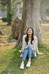 Naklejka premium Portrait of millennial woman relaxing, breathing fresh air and enjoying a day in the park on summer