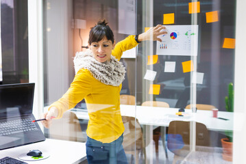 Businesswoman explaining chart note to colleagues in creative office
