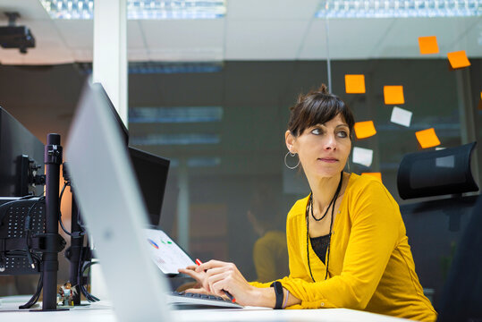 Side view of businesswoman using computer in office looking away