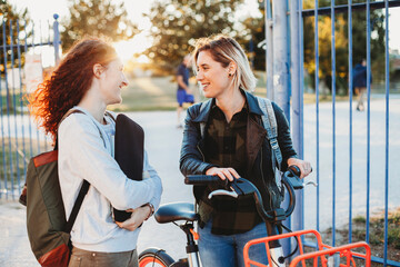 Two young student talking at the park together