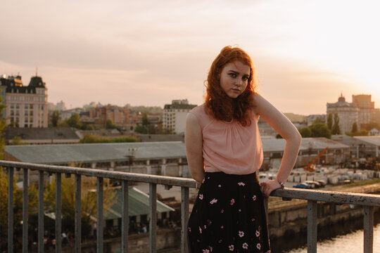 Portrait of young cute woman standing on bridge in city
