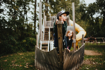 a boy and a girl play on a pirate ship