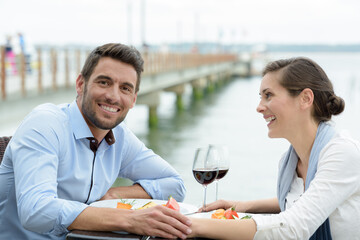 couple having a meal on terrace overlooking a river