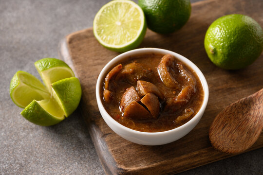Traditional Sri Lankan Lime Pickle of lime, salt, chilli, pepper on brown background. Close up.