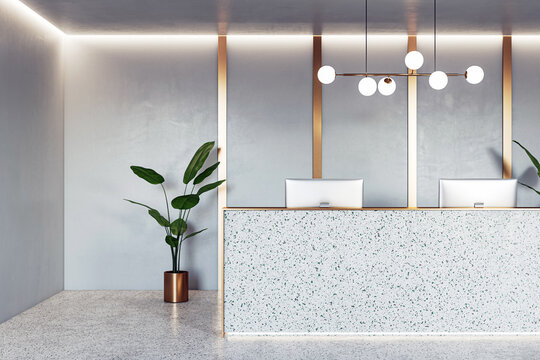 Front view on stylish reception desk with modern computers, golden wall decoration background, green plant on concrete floor and illuminated ceiling. 3D rendering