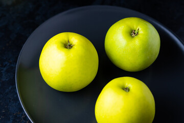 Ripe green apple fruits on dark stone table. Top view with copy space. Flat lay