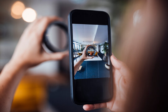 Businesswoman photographing circular equipment through smart phone