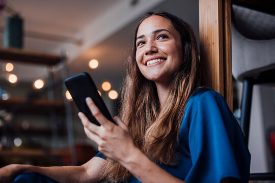 Happy businesswoman with smart phone at office