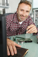happy cheerful man fixing computer