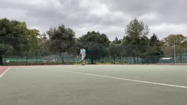 aerial top view of caucasian male tennis player holding racket and hitting ball