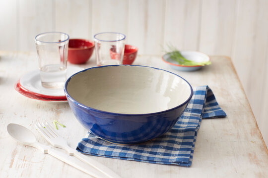 Empty bowl on checked dish towel