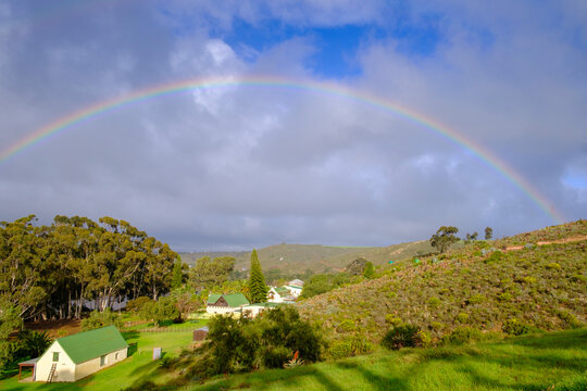 South Africa, Western Cape, Malgas, Rainbow arching over small secluded village