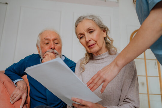Senior woman reading medical report with man at home
